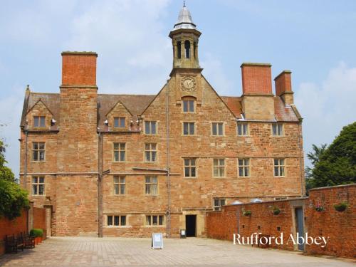 an old brick building with a clock tower on top at Newly Refurbished 2-Bed with Patio, Netflix & Wi-Fi in Worksop