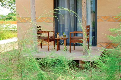 a patio with two chairs and a table on a building at King baobab lodge in Diakhanor