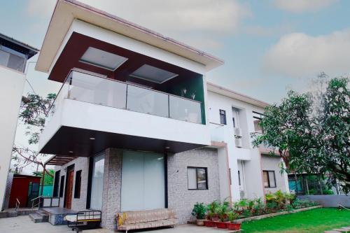 a white building with a balcony on top of it at Royal Twin Lonavla - 12BHK Luxury Villa with Turf in Lonavala