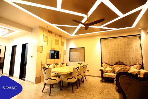 a dining room with a table and chairs and a ceiling at Royal Twin Lonavla - 12BHK Luxury Villa with Turf in Lonavala
