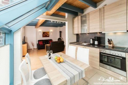 a kitchen with a table with a bowl of fruit on it at 20 Ferienwohnung im Fritz-Bleyl-Weg 16a OG in Burg auf Fehmarn