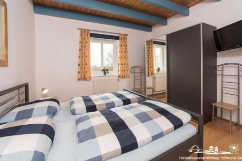 a bedroom with a bed with a black and white checkered blanket at 20 Ferienwohnung im Fritz-Bleyl-Weg 16a OG in Burg auf Fehmarn