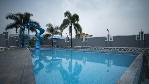 a swimming pool with a blue slide in a resort at Royal Twin Lonavla - 12BHK Luxury Villa with Turf in Lonavala
