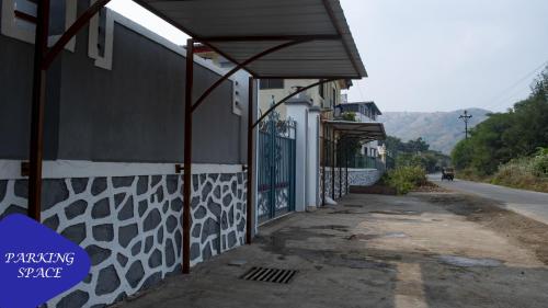 a building with a gate on the side of a street at Royal Twin Lonavla - 12BHK Luxury Villa with Turf in Lonavala