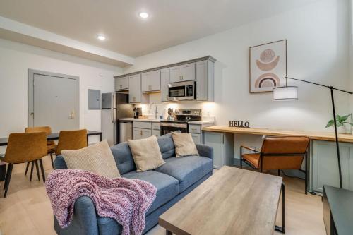 a living room with a blue couch and a kitchen at Bright and Modern Studio in Louisville # 109 in Louisville