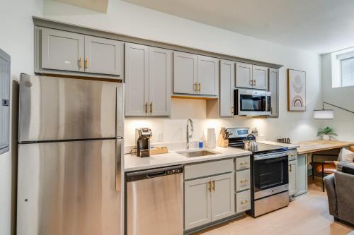 a kitchen with white cabinets and a stainless steel refrigerator at Bright and Modern Studio in Louisville # 109 in Louisville