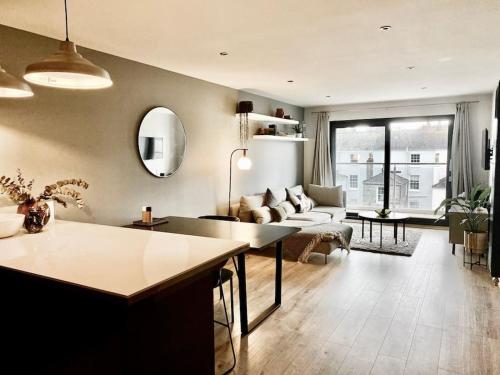 a living room with a couch and a table at Luxury apartment close to Theatre, Barbican & Hoe 2 kings or 4 single beds secure covered parking in Plymouth