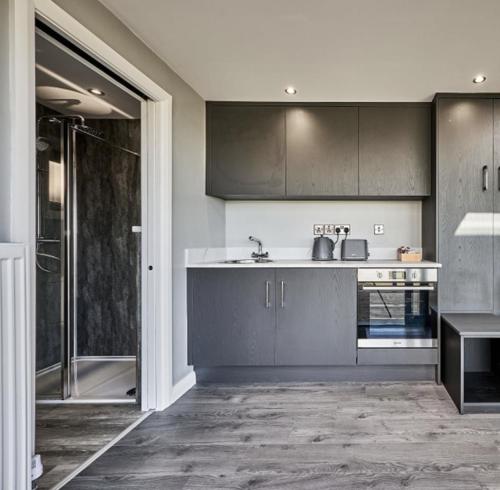 a kitchen with gray cabinets and a sink at Umry-Calm Farm Stays in Feeny