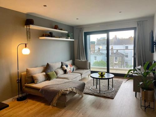 a living room with a couch and a table at Luxury apartment close to Theatre, Barbican & Hoe 2 kings or 4 single beds secure covered parking in Plymouth