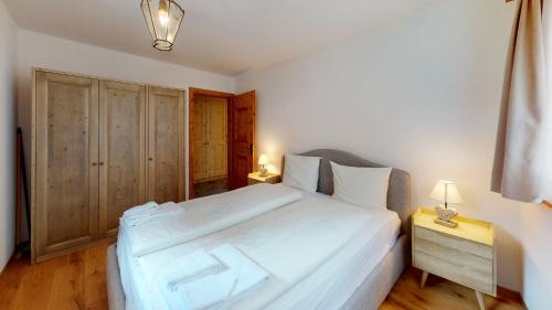 a bedroom with a large white bed and a night stand at Apartment Ambretta EG in Champfer