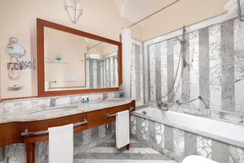 a bathroom with a tub and a sink and a mirror at Alimuri Bay Resort in Meta