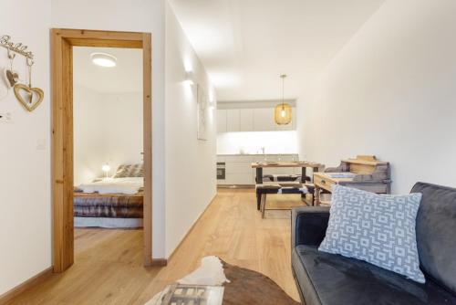 Una sala de estar con un sofá y un dormitorio. en Apartment Arsa 14, en Silvaplana