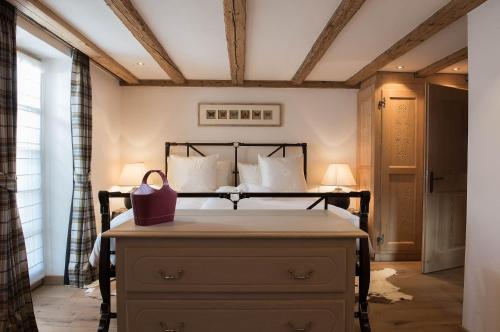a bedroom with a bed and a dresser in a room at Hotel Olden in Gstaad
