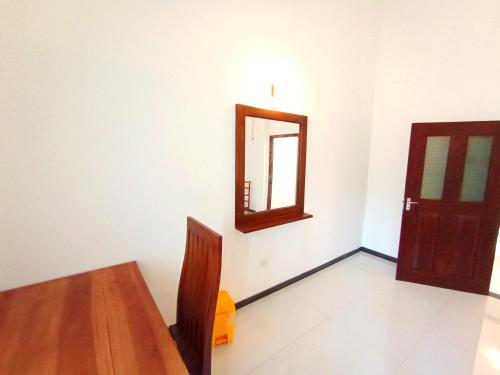 a dining room with a table and a mirror at Would Villa Mirissa in Mirissa