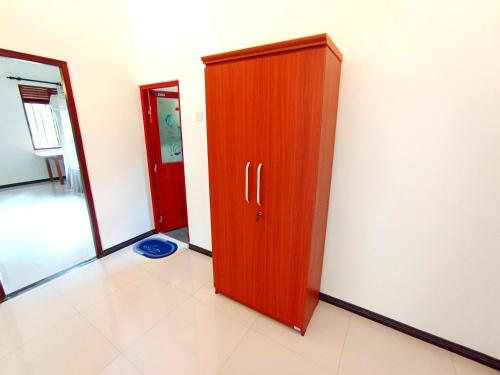 a wooden cabinet in the corner of a room at Would Villa Mirissa in Mirissa