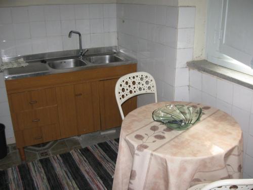 a kitchen with a table and a sink and a table and chairs at Agriturismo Il Casotto in Maida