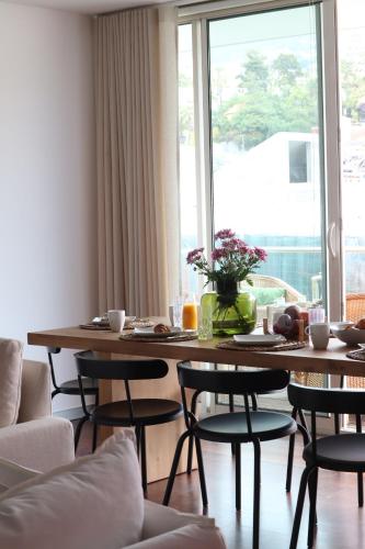 a dining room table with chairs and a large window at Heart of Funchal 4 BD Apartment - Casa d Alma in Funchal