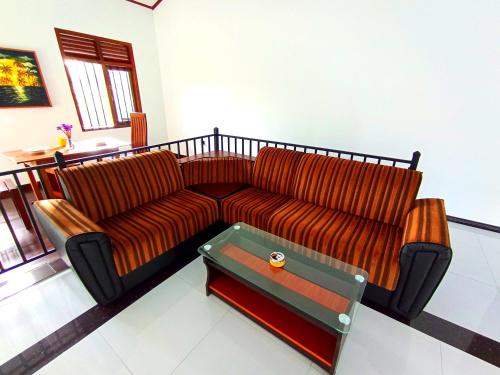 a leather couch in a living room with a coffee table at Would Villa Mirissa in Mirissa