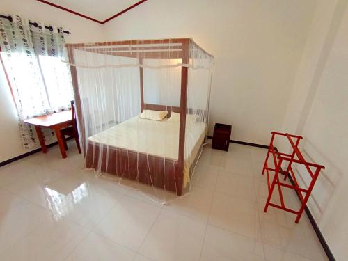 a bedroom with a canopy bed and a table at Would Villa Mirissa in Mirissa