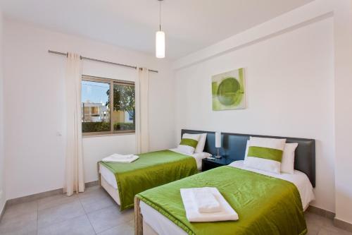 two beds in a room with a window at Albufeira Sunny Apartment 3 With Pool by Homing in Albufeira