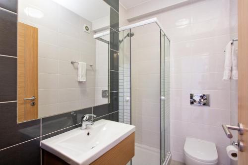 a bathroom with a sink and a glass shower at Albufeira Sunny Apartment 3 With Pool by Homing in Albufeira