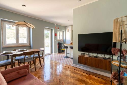 a living room with a television and a dining room at Charm House Sintra 45 - Pena Garden Flat in Sintra