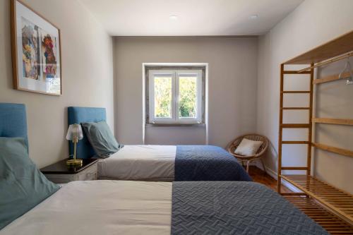 a bedroom with two beds and a window at Charm House Sintra 45 - Pena Garden Flat in Sintra