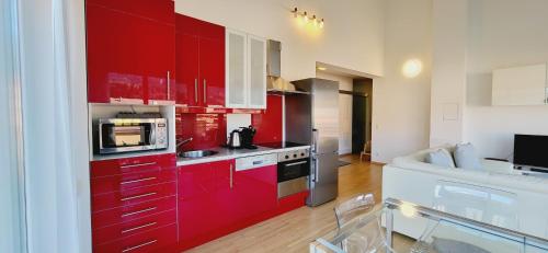 a red kitchen with white cabinets and a stove at Apartment Bergblick by Alpenidyll Apartments in Weißenbach