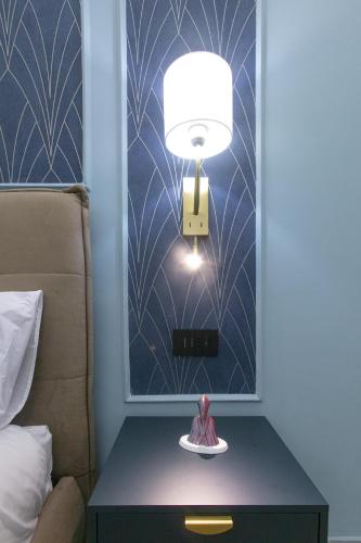 a lamp on a table next to a bed at Pignasecca Domus in Naples