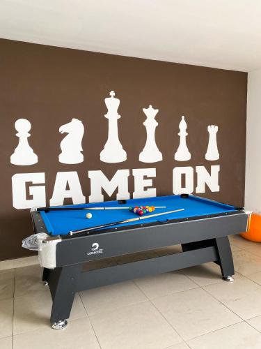 a pool table in front of a wall with chess pieces at Veranda-2BR,4pax I 5mins to CIQ and KSL I Fast-Wifi in Johor Bahru