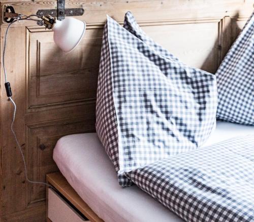a bed with blue and white pillows on it at Fleischerei - Apartments, Cafe & Weinbar in Hinterstoder