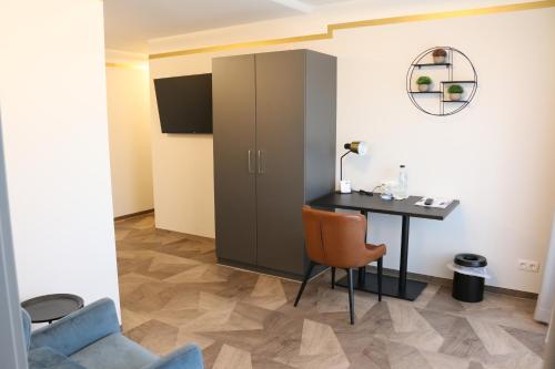 a room with a desk and a cabinet and a chair at Hotel Tanneck in Bad Wörishofen