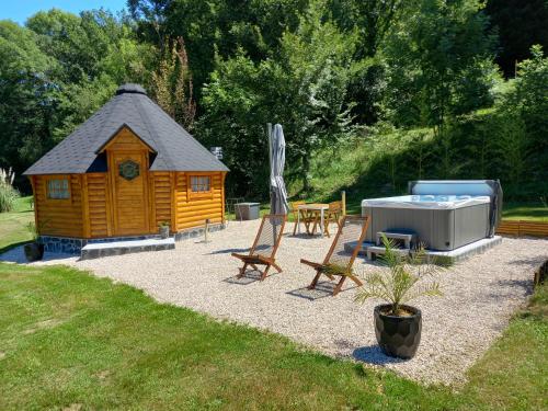 a cabin with a hot tub and a table and chairs at L'Oasis Des Pyrénées in Campuzan