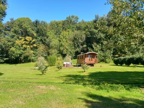 a tree house in a field with trees in the background at L'Oasis Des Pyrénées in Campuzan