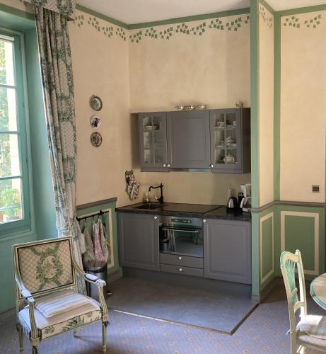 a kitchen with a sink and a table and a chair at Chateau appartement tussen Mont Ventoux en Luberon in Montbrun-les-Bains