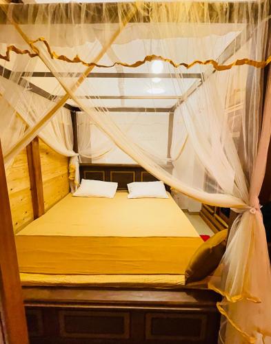 a bedroom with a bed with a mosquito net at YOUTHENI VILLA in Weligama
