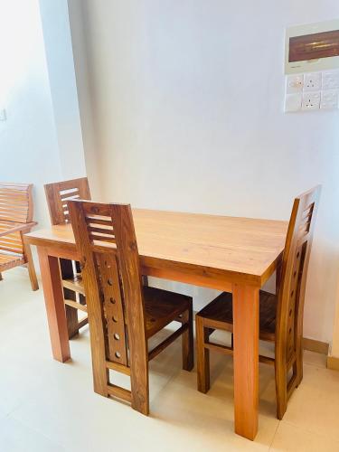 a wooden dining room table with two chairs and a table at YOUTHENI VILLA in Weligama