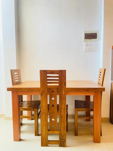 a wooden table with two chairs and a wooden table and a table and chairs at YOUTHENI VILLA in Weligama