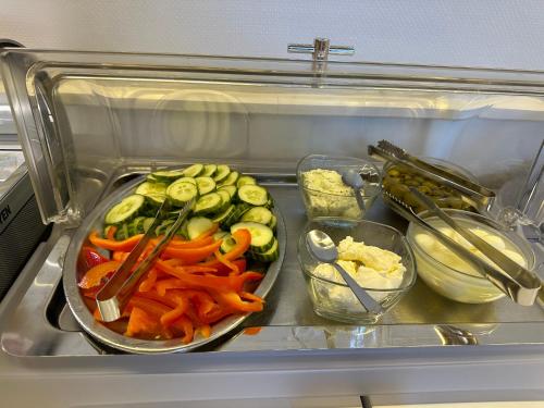 a refrigerator filled with vegetables and other food items at Hotel Barbarossa Karlsruhe Stadtmitte in Karlsruhe