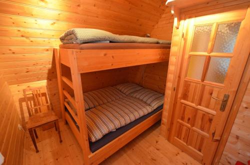 - une chambre avec 2 lits superposés dans une cabane en rondins dans l'établissement Meadow Ranch Holiday Home, à Jaroslavické Paseky