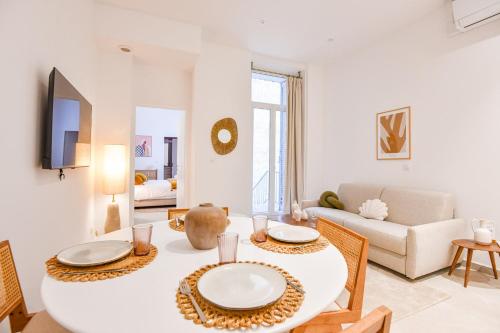 un salon blanc avec une table et des chaises dans l'établissement Appart 1 ch clim proche Vieux-Port et St-Charles, à Marseille
