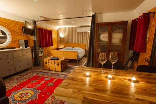 - un salon avec une table et deux verres à vin dans l'établissement Magnifique Péniche cosy et spacieuse à Toulouse, à Toulouse
