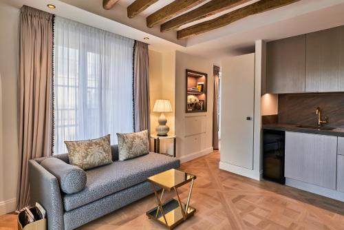 a living room with a couch and a table at Maison Barrière Vendôme in Paris