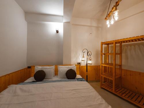 a bedroom with a bed with two pillows on it at The Rustic Jibhi - Backpackers Hostel in Jibhi