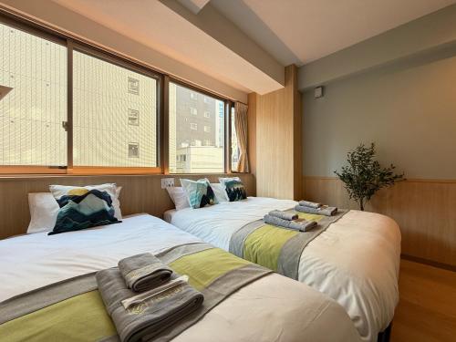 two beds sitting next to each other in a room at nestay inn tokyo tsukiji in Tokyo