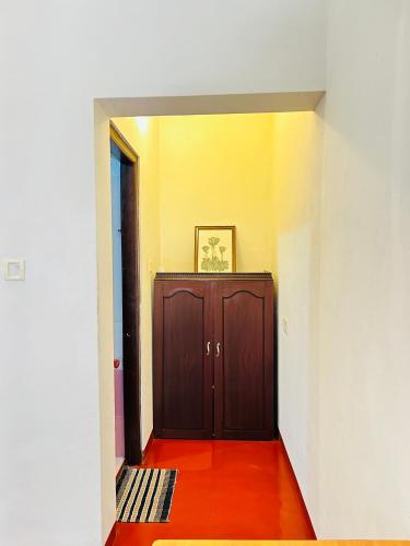 a hallway with a brown door and a red floor at Marari Beach Homestay in Mararikulam