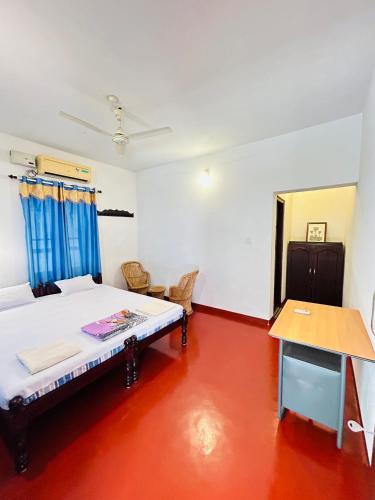 a bedroom with a bed and a table in it at Marari Beach Homestay in Mararikulam