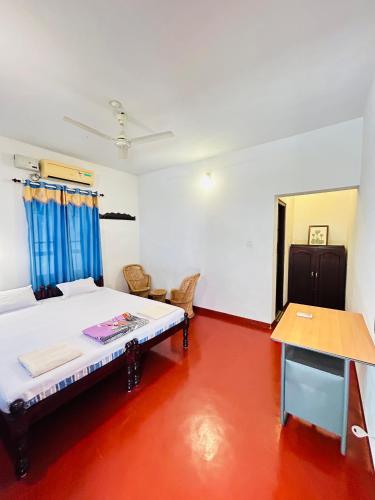 a room with a bed and a table in it at Marari Beach Homestay in Mararikulam