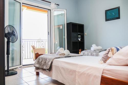 a hotel room with two beds and a balcony at Villa Sunrise apartment in Gouvia
