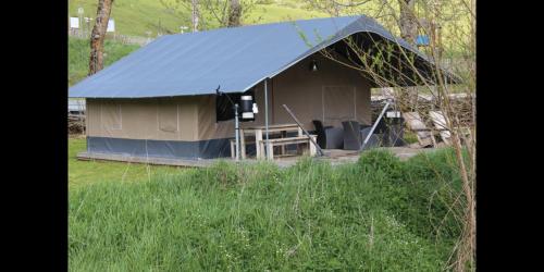 a large tent with a blue roof in a field at Le Silence du Midi in Comus
